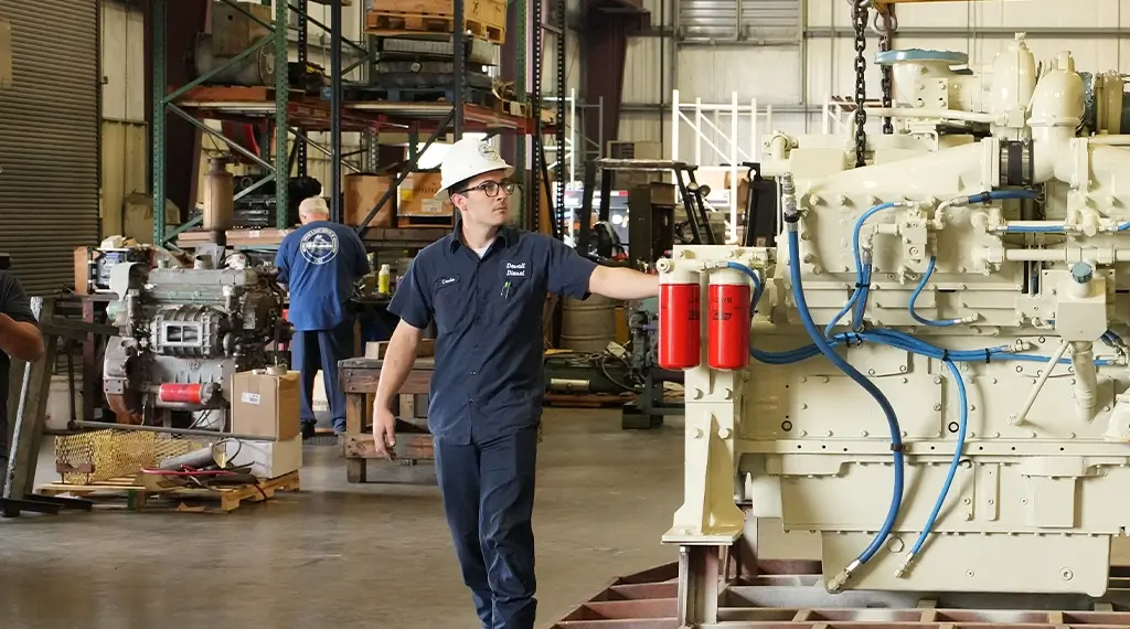 Devall Diesel technicians inspecting a large diesel generator in a warehouse