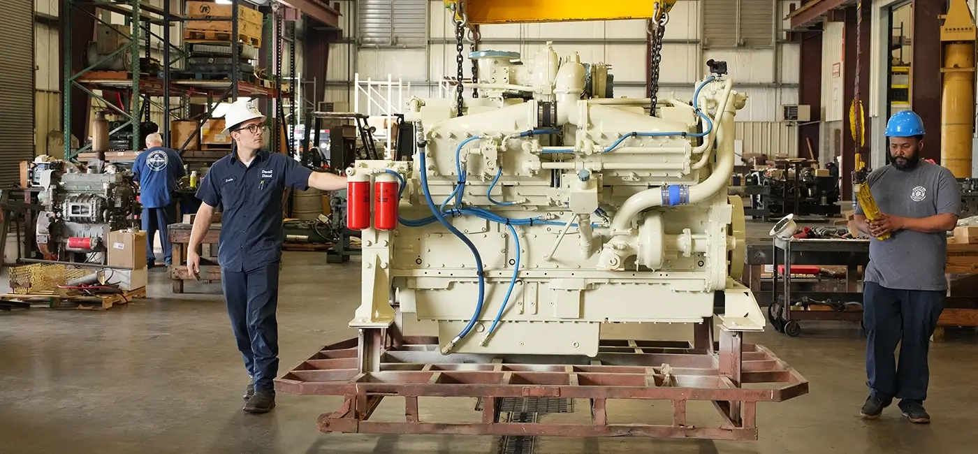 Devall Diesel technicians inspecting a large diesel generator in a warehouse