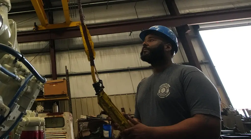 A Devall Diesel Technician preparing to lift a large, white diesel generator