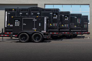 Black mobile diesel generators lined up in rows outside