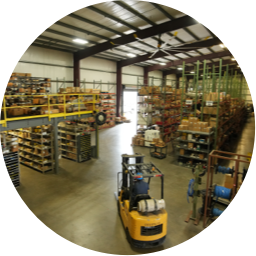 A Devall Diesel warehouse worker driving a forklift through a parts warehosue