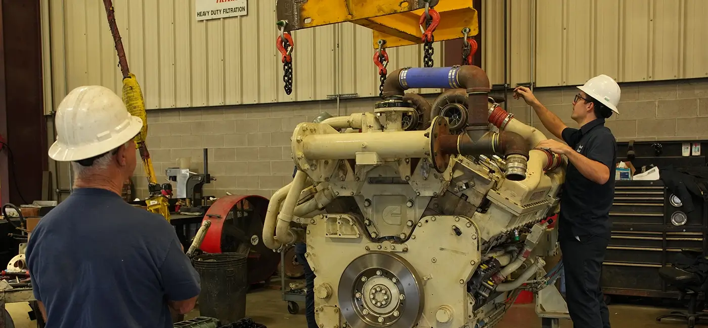 Two Devall Diesel workers examining a large diesel engine