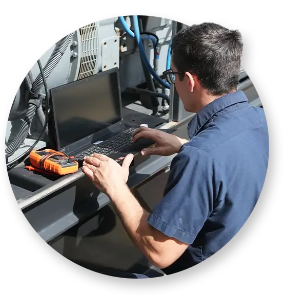 A Devall Diesel Technician looking at generator specs on his laptop in the field