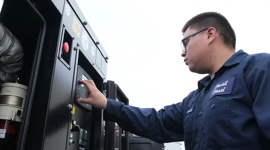 A Devall Diesel Technician turning on a diesel generator