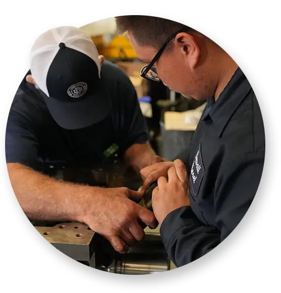 Two Devall Diesel workers examining a diesel engine part together