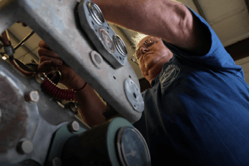 Looking up at a Devall Diesel technician as he tightens bolts on a diesel engine