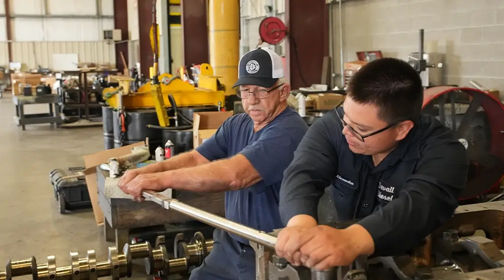 Two Devall Diesel workers tightening a bolt together