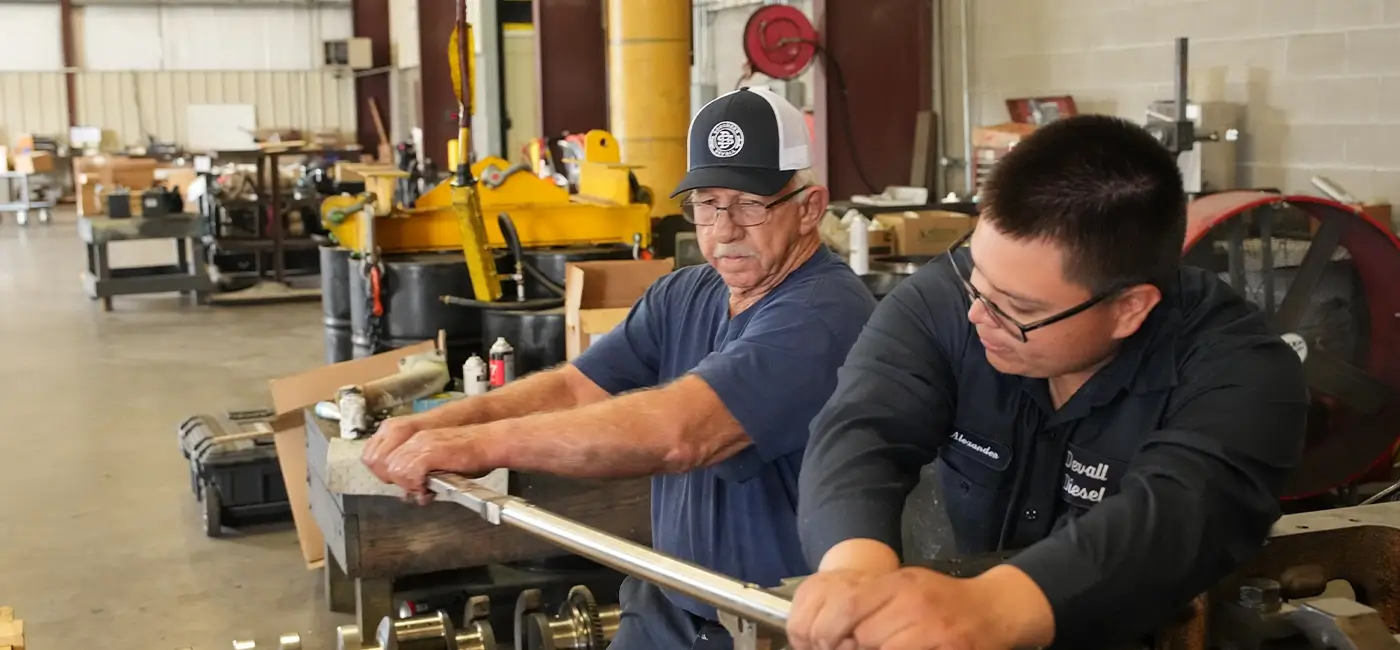 Two Devall Diesel workers tightening a bolt together