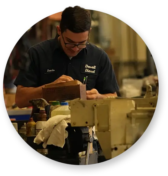 A Devall Diesel technician taking screws out of a small wooden box