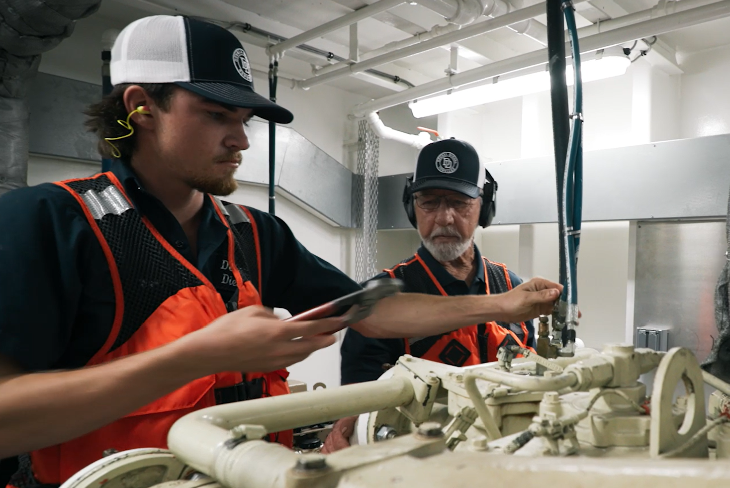 Two Devall Diesel workers tightening a bolt together